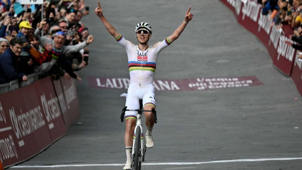 Tadej Pogacar raises his arms aloft after crossing the line to win the Strade Bianche 2025 road race