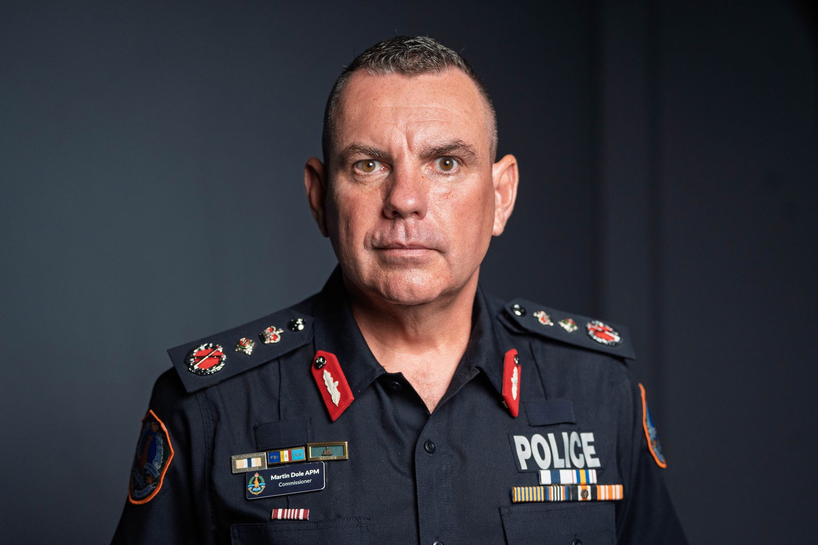 A man in a police uniform, looking serious.