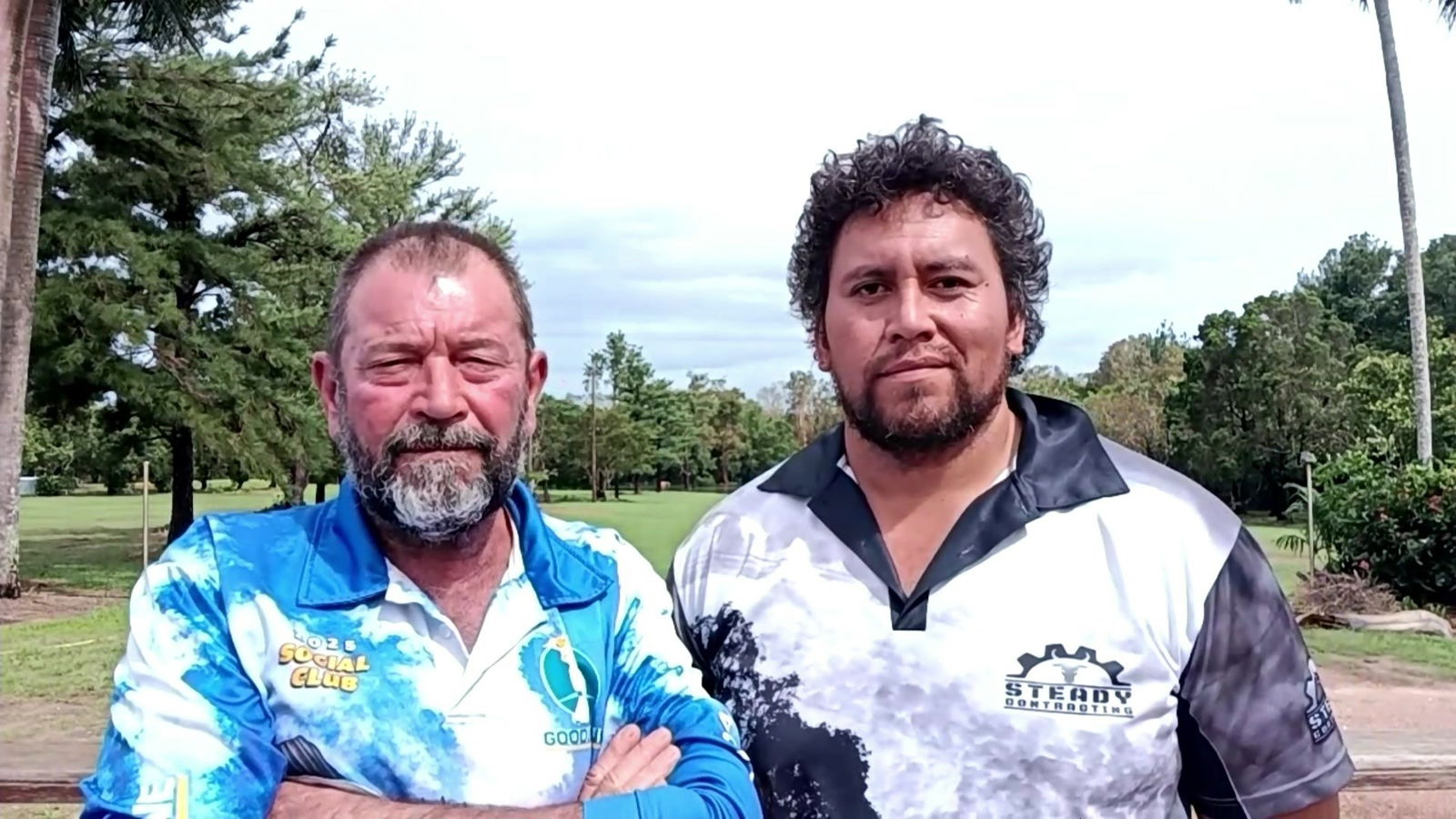 Len McKinley and Oliver Tata in front of a golf course. 