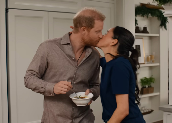 Prince Harry and Meghan Markle sharing a kiss in a domestic kitchen setting, related to Netflix cuts ties news.