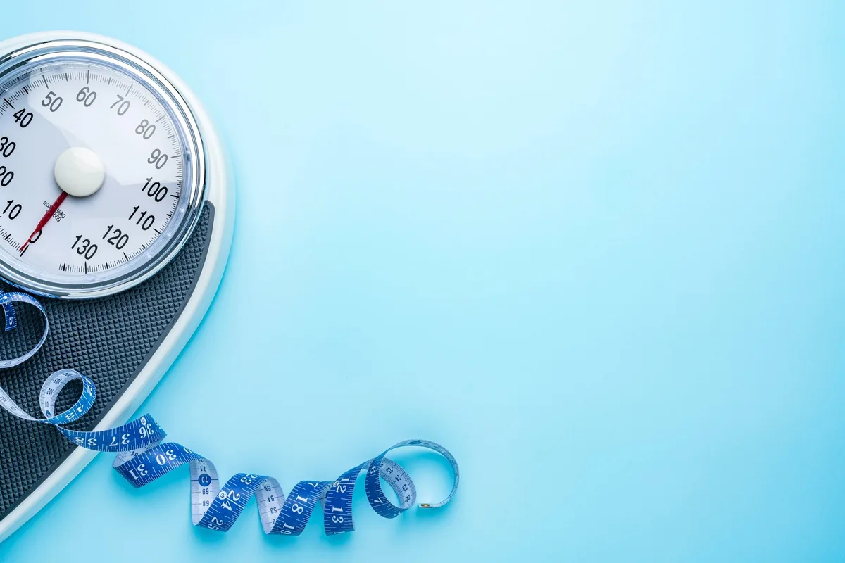 Bathroom scales on a bright blue background.