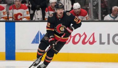 Ottawa Senators #52 MacKenzie Weegar skating with the puck on ice.