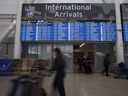 Travellers tote their luggage at the Terminal 1 international arrivals area of Toronto Pearson International Airport on Sept. 26, 2022.