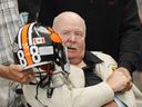 B.C. Lions legend Tom Brown grips the hand of fellow legend Willie Fleming (right) while Norm Fieldgate holds the helmet at team practice at B.C. Place stadium Thursday morning, August 6, 2009. Brown has died at the age of 89.