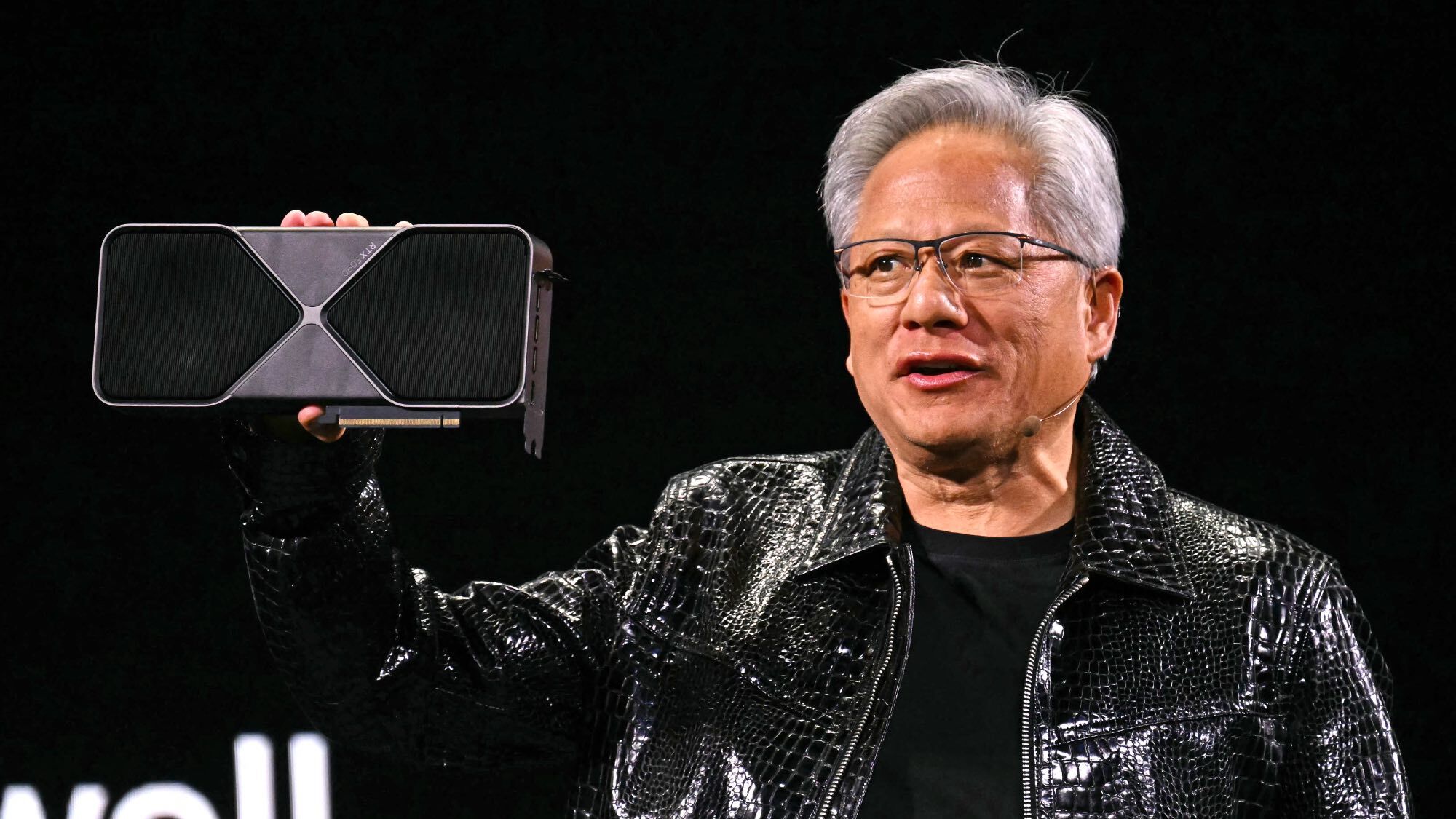 Jensen Huang holding an Nvidia RTX GPU.