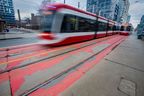 A TTC streetcar passes by the peeling red paint on the RapidTO surface transit lanes along Bathurst St., near Front St., in downtown Toronto on Thursday December 25, 2025.