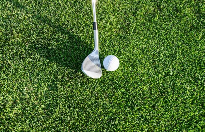 robert-ruggiero-golf-unsplash - Ottawa Road Trips close up of a golf club head beside a golf ball on a green