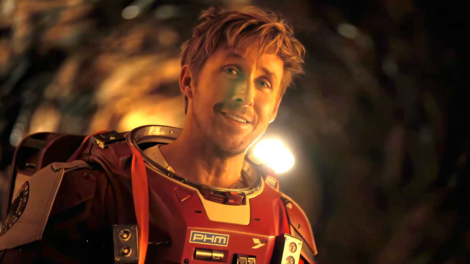 Ryan Gosling as Ryland smiling toward Rocky with his helmet off in the tunnel in Project Hail Mary