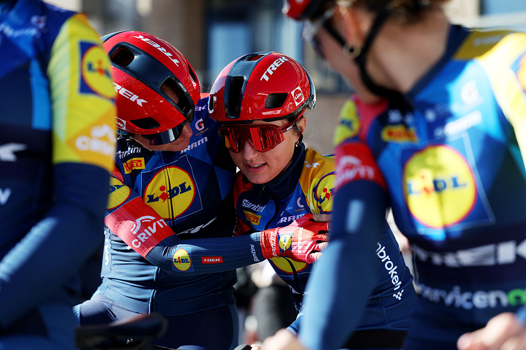 A Lidl-Trek teammate hugs a tired Fleur Moors at the finish of Nokere Koerse Women 2026