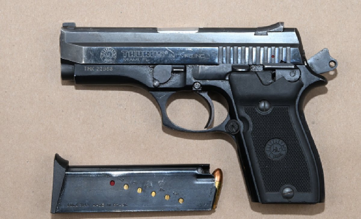 A silver Taurus semi-automatic handgun with a black grip is shown beside a detached magazine containing several rounds of ammunition, displayed as seized evidence.
