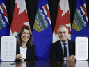 Prime Minister Mark Carney, right, signs a memorandum of understanding with Alberta Premier Danielle Smith in Calgary on Nov. 27, 2025.