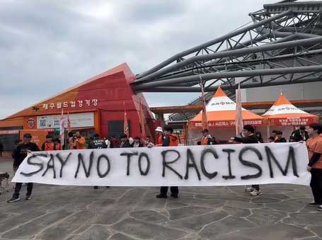 Why did Jeju soccer fans hold anti-racism placards before match?