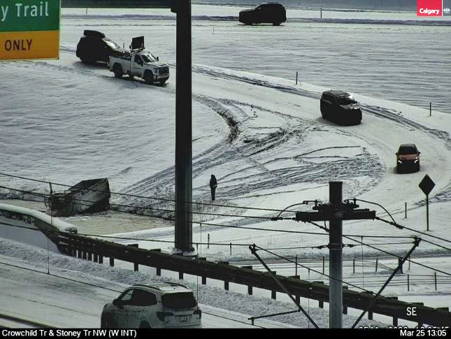 A dump truck sits in a pond after it failed to navigate a ramp at the intersection of Crowchild Trail and Stoney Trail northwest in Calgary.