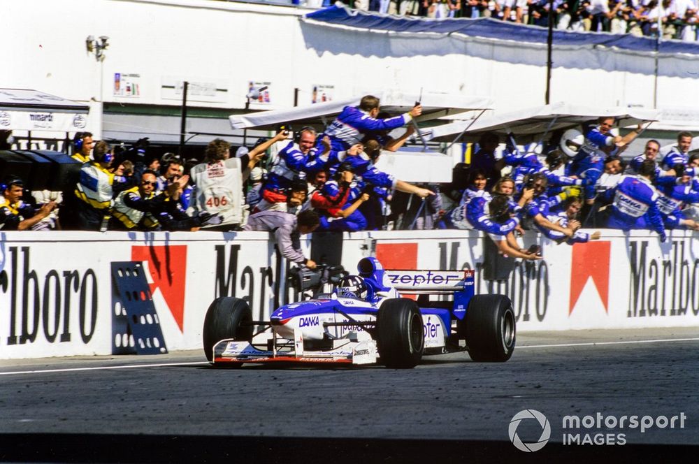 The Arrows team celebrates as Damon Hill, Arrows A18 Yamaha, crosses the finish line to take a podium finish