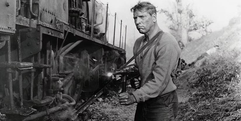 Burt Lancaster as Paul Labiche pointing his gun at a target offscreen in The Train (1964)