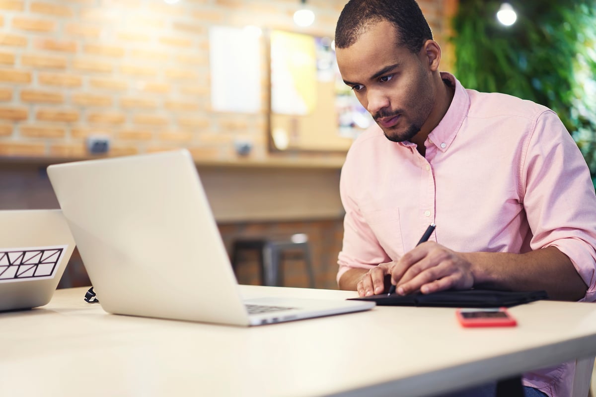 An investor works on a laptop in an office.