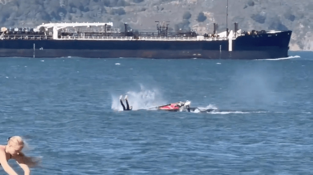 Windsurfer Eric Kramers falls off his board after colliding with a surfacing whale.