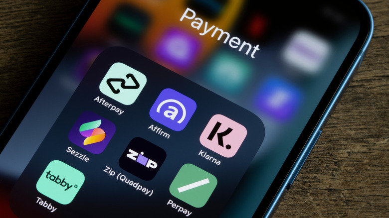 Person holding smartphone with buy now pay later apps on screen