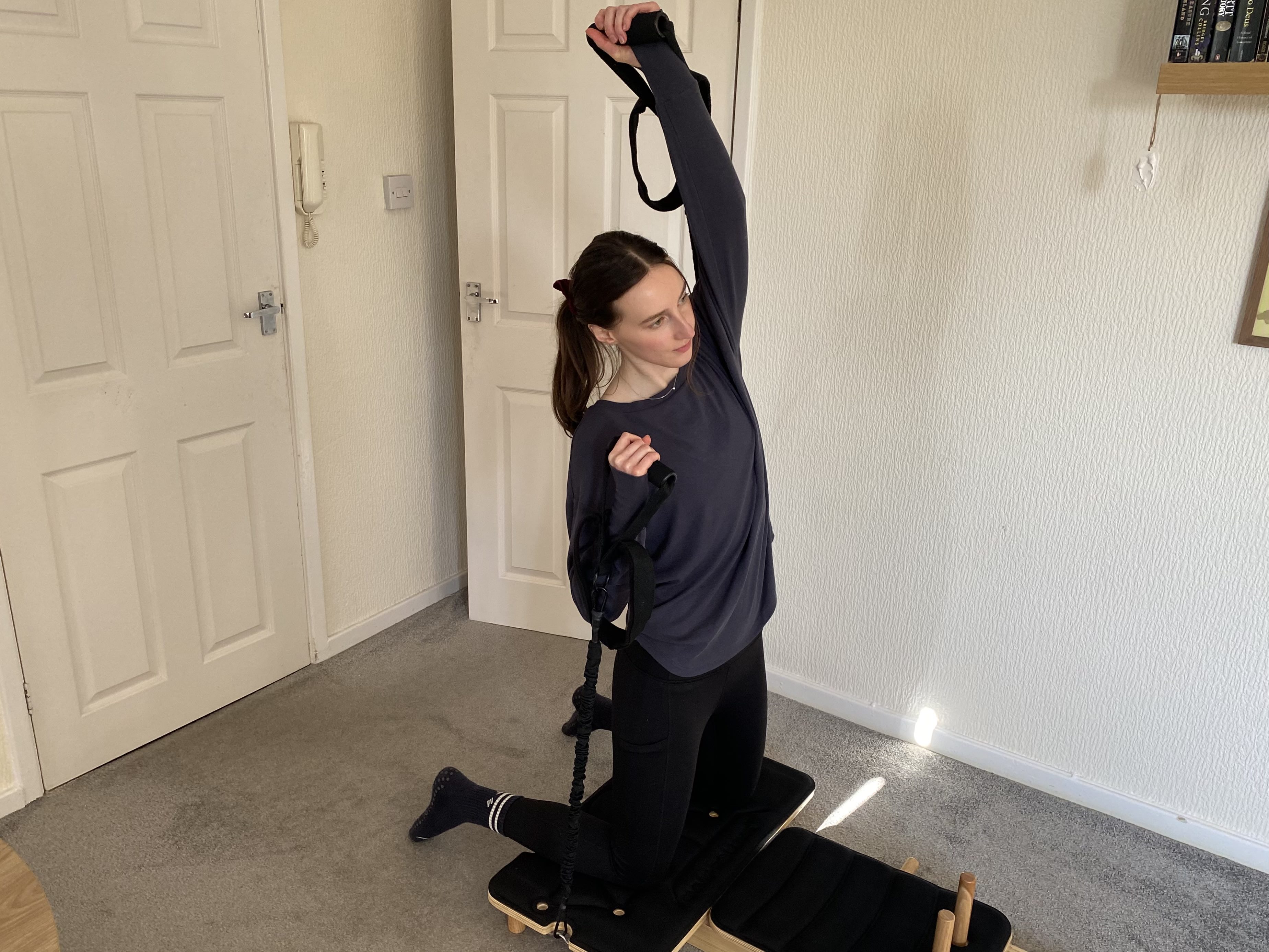 woman uses reformer pilates machine