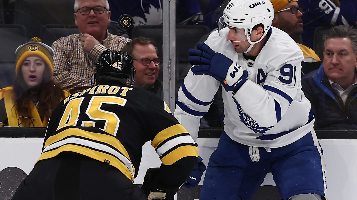 Mar 24, 2026; Boston, Massachusetts, USA; Toronto Maple Leafs center John Tavares (91) eyes a loose puck over the head of Boston Bruins defenseman Jonathan Aspirot (45) during the first period at TD Garden. Mandatory Credit: Winslow Townson-Imagn Images