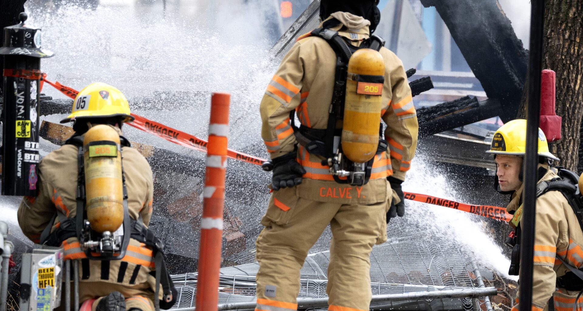 Montreal firefighters spray down the remains of a small building.