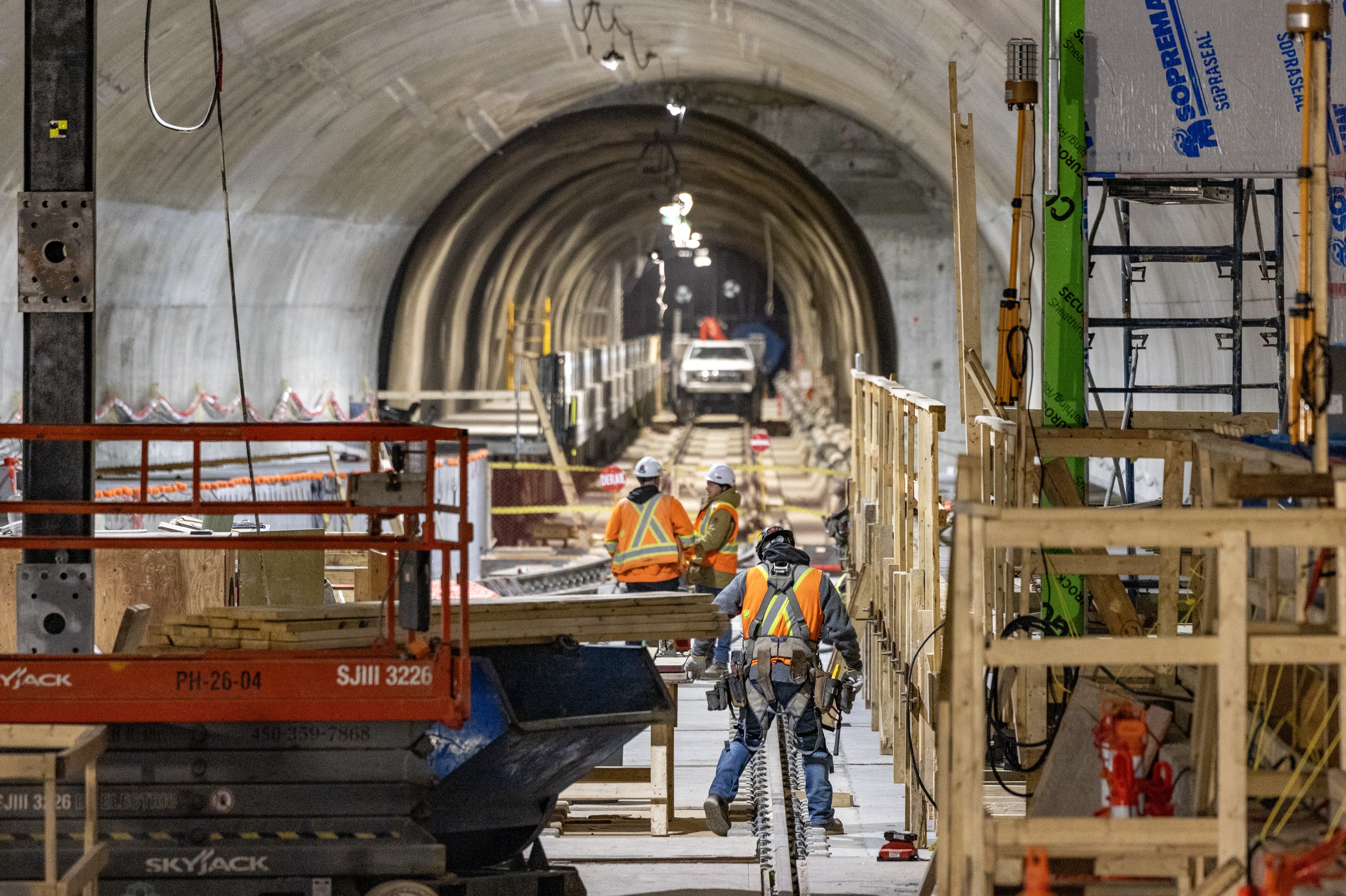 Construction workers in the tunnel of the REM station at Trudeau airport.