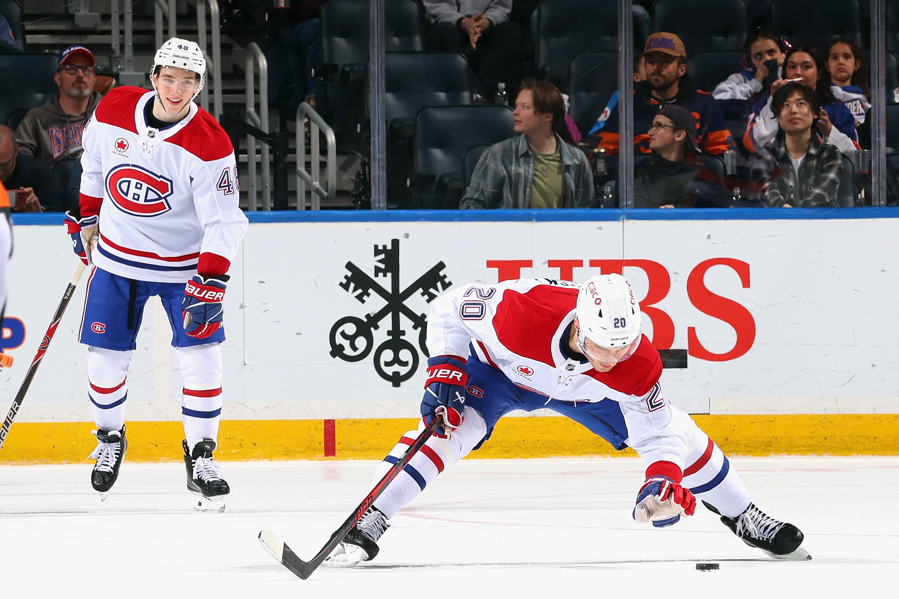 Juraj Slafkovsky of the Montreal Canadiens retrieves a puck from the ice.