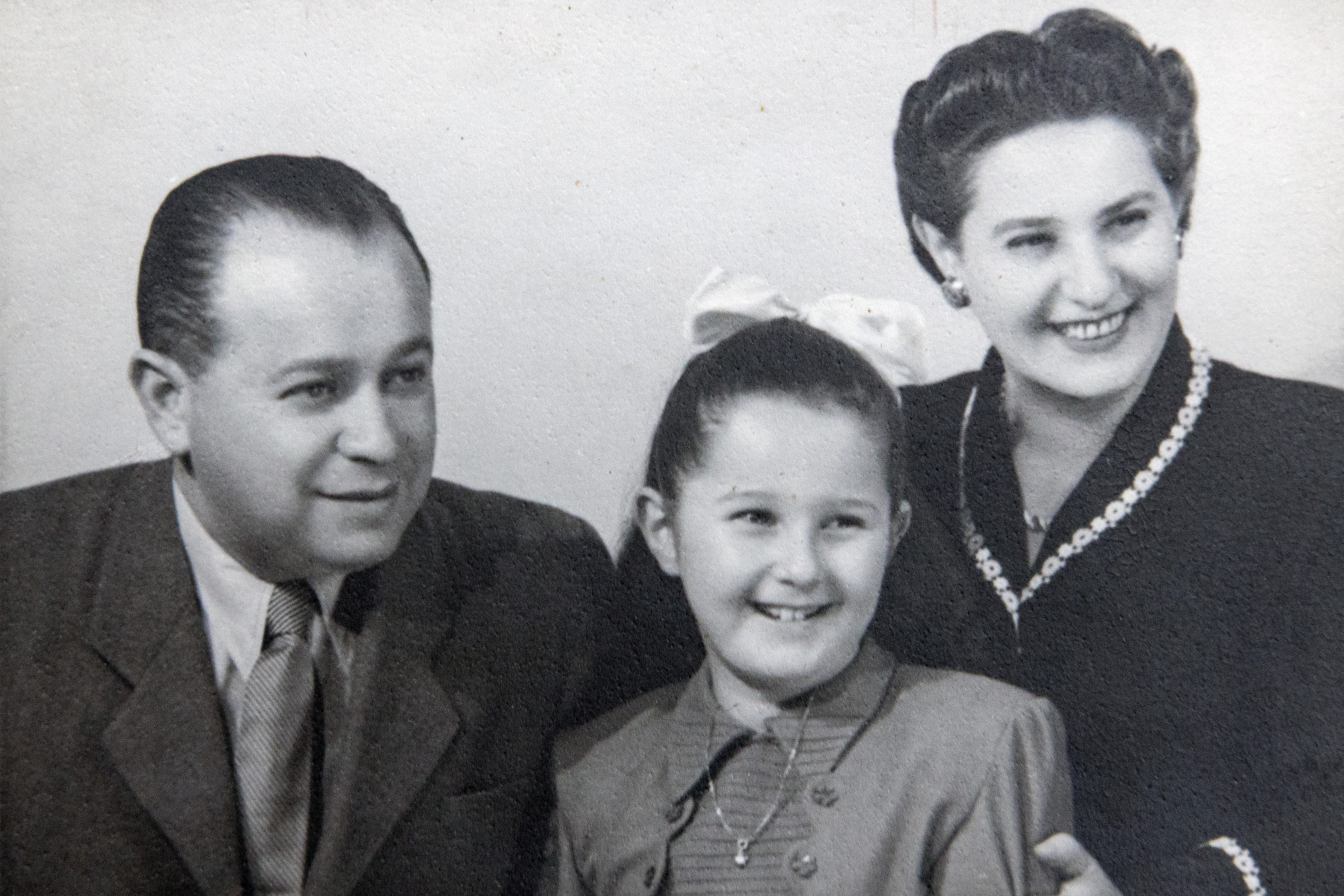 A vintage black and white photo of a man, woman and child smiling.