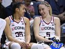 Azzi Fudd (left) and Paige Bueckers smile at each other on the bench during an NCAA game against Arkansas State in 2025.