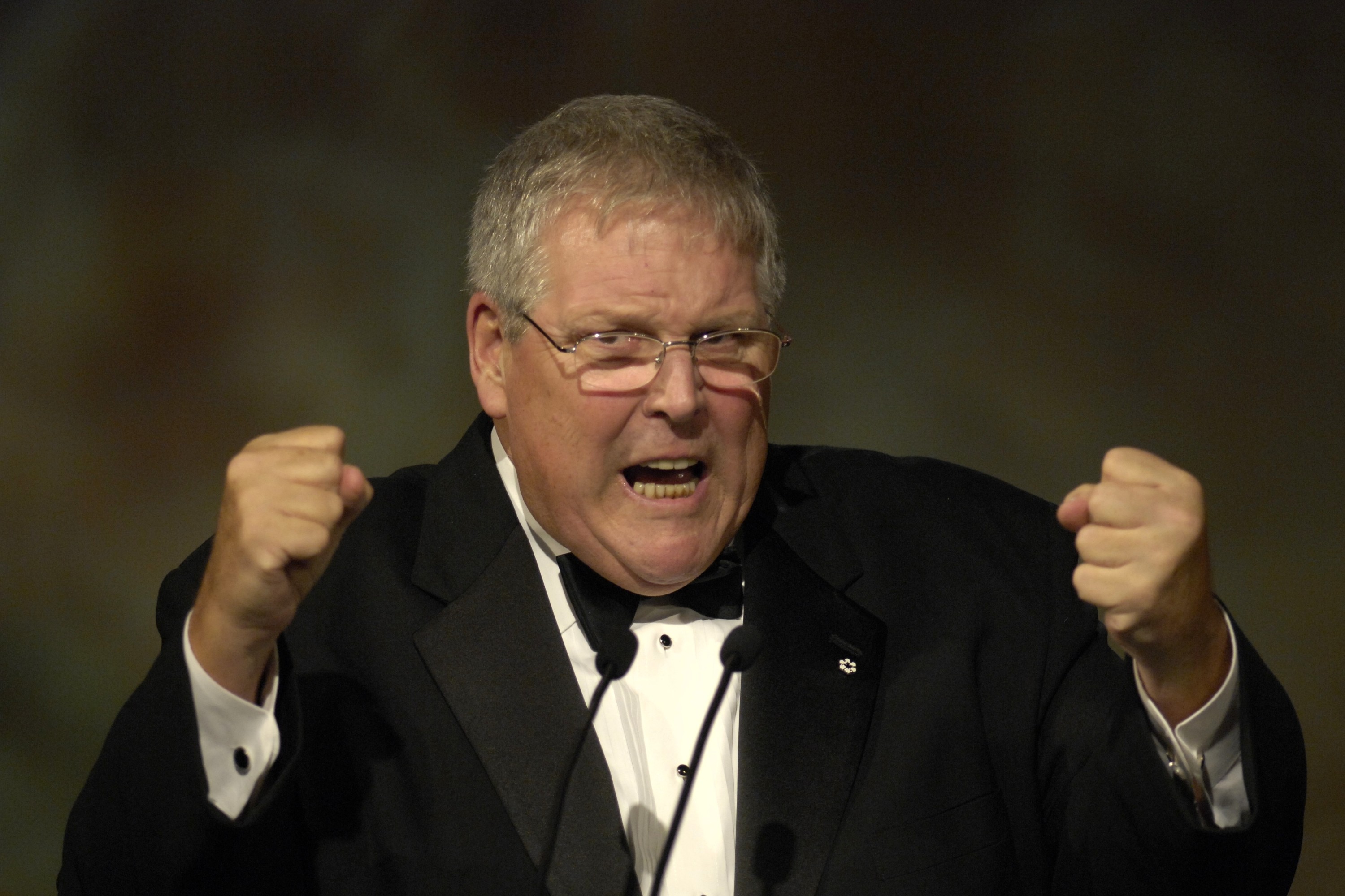Promoter Donald Tarlton raises his fists dramatically while making a speech.