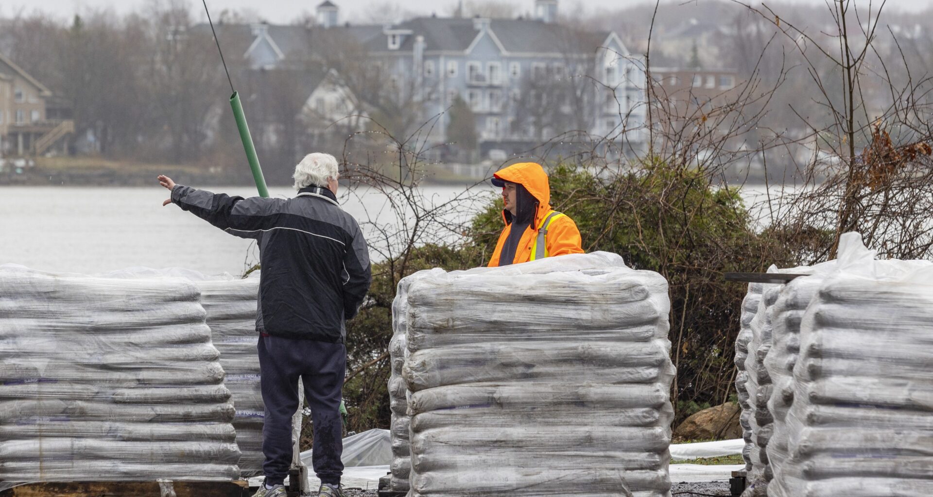 Pallets of sandbags used to make a dike against the rising Rivière des Prairies can be seen in this file photo from 2023.