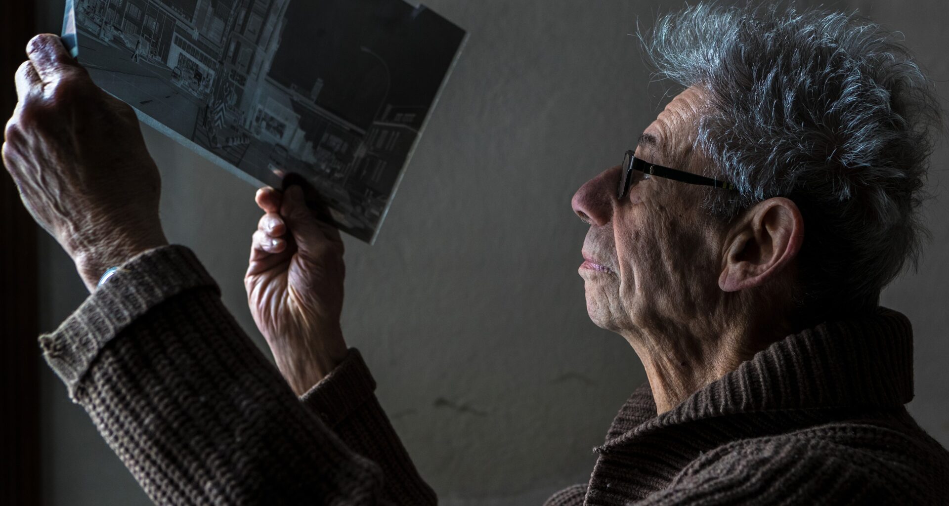 Gabor Szilasi looks over an 8x20 negative of a Montreal street scene at home in Westmount on Friday, Dec. 22, 2017.
