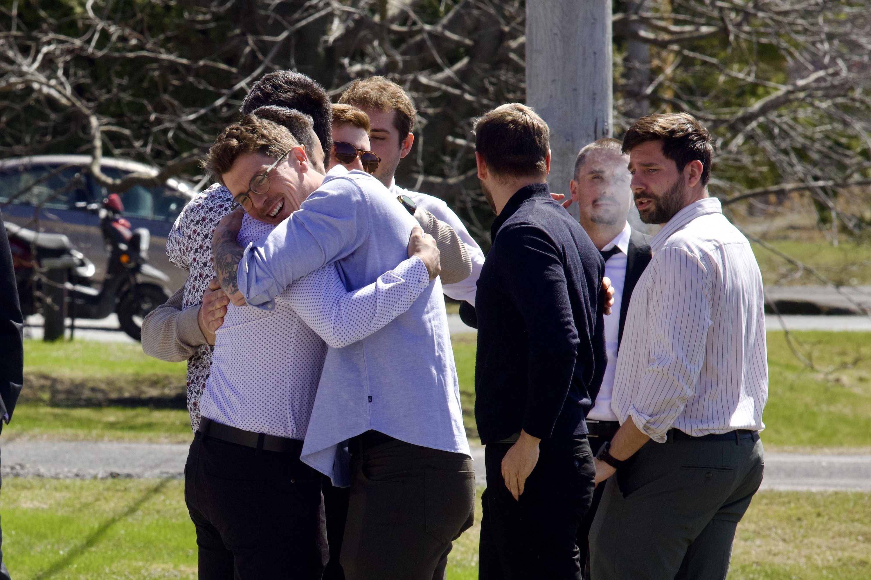Mourners comfort each other at a funeral.