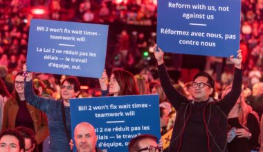 Quebec doctors hold up signs against Bill 2 at a packed Bell Centre last November.