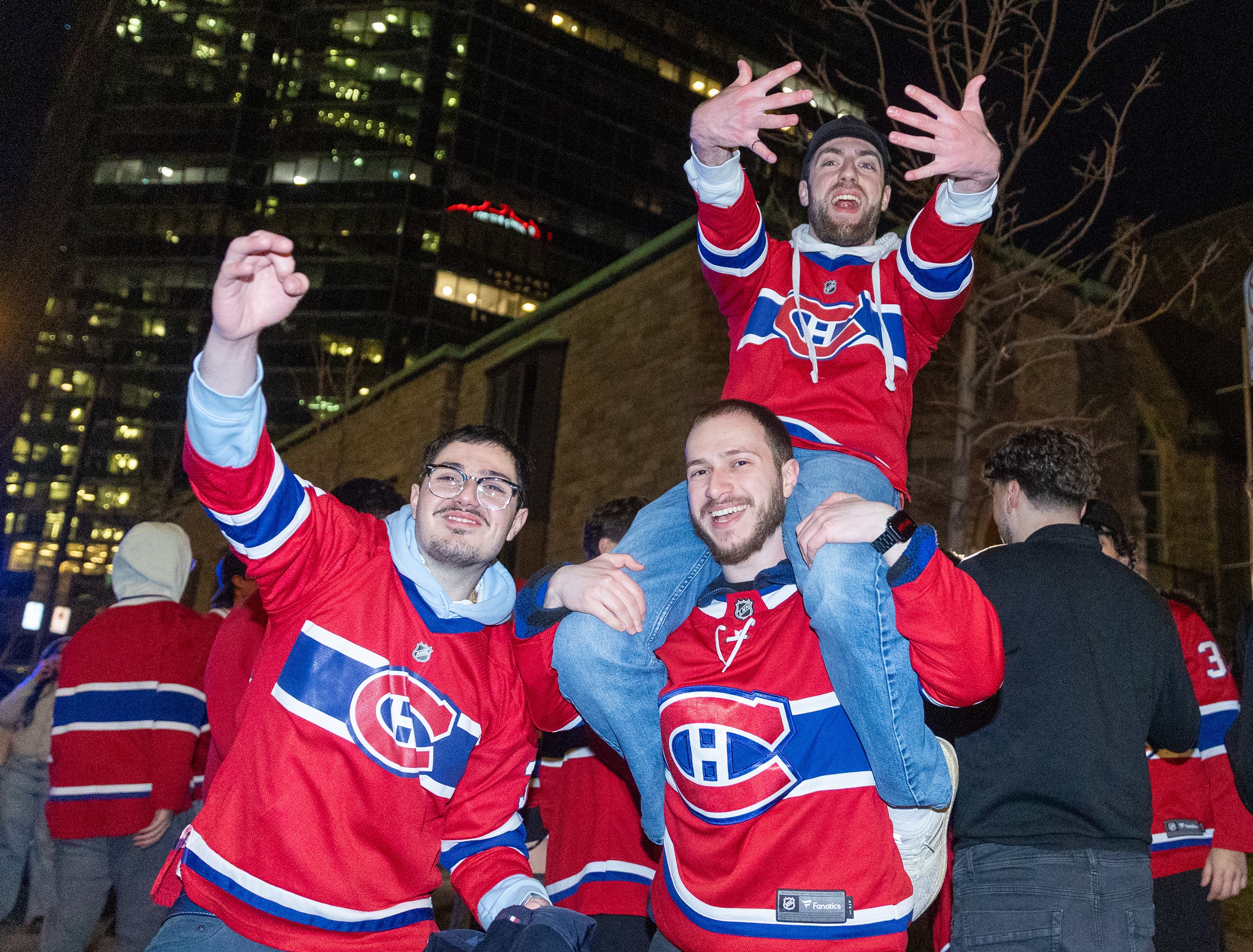 Three Canadiens fans, one on top of his buddy's shoulders, celebrate Friday night's OT win.