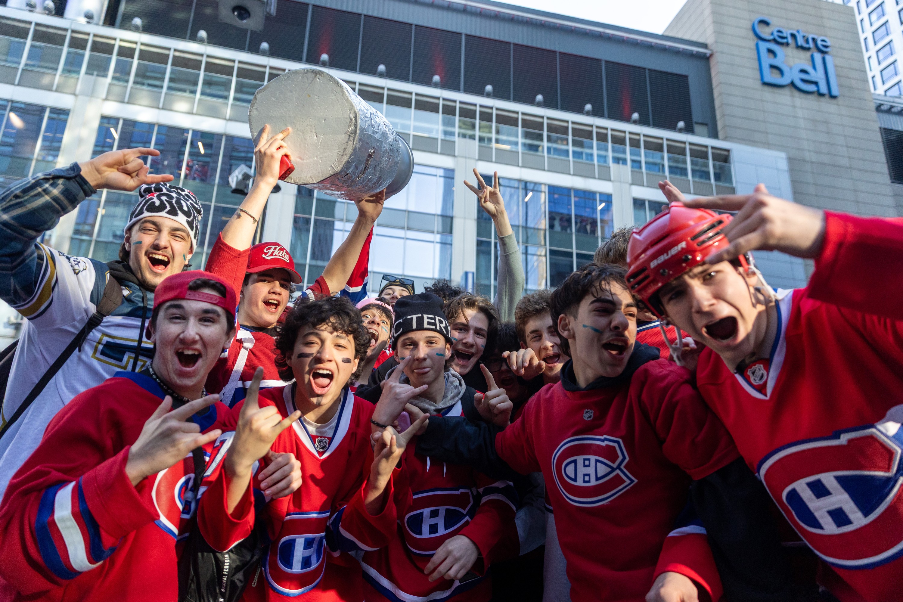 Canadiens fans throng outside the Bell Centre before Game 3, one holding aloft a replica Stanley Cup.