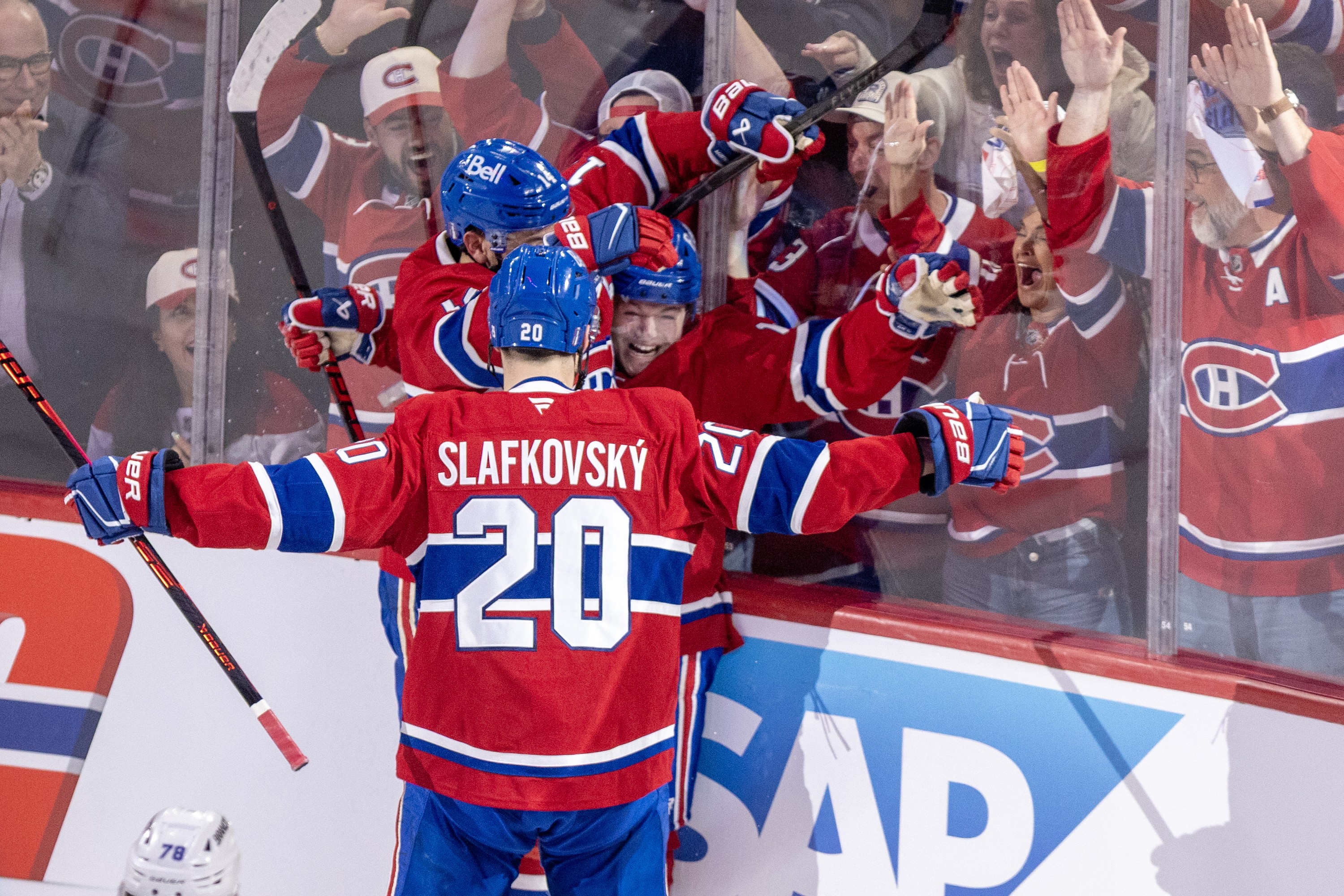 Montreal Canadiens' Cole Caufield celebrates his goal against the Tampa Bay Lightning with Juraj Slafkovsky and Nick Suzuki.