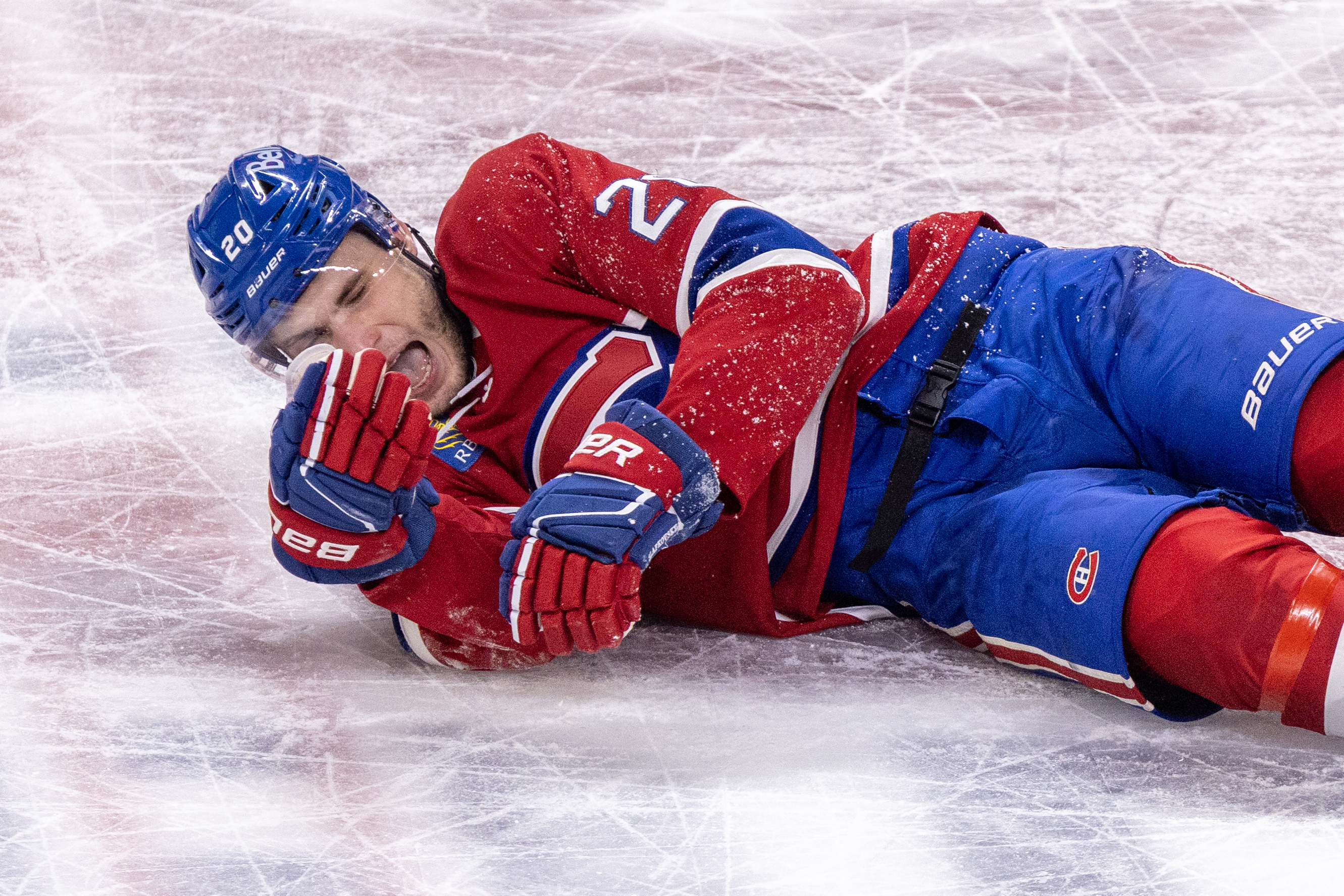 Montreal Canadiens' Juraj Slafkovsky grimaces as he lies on the ice.