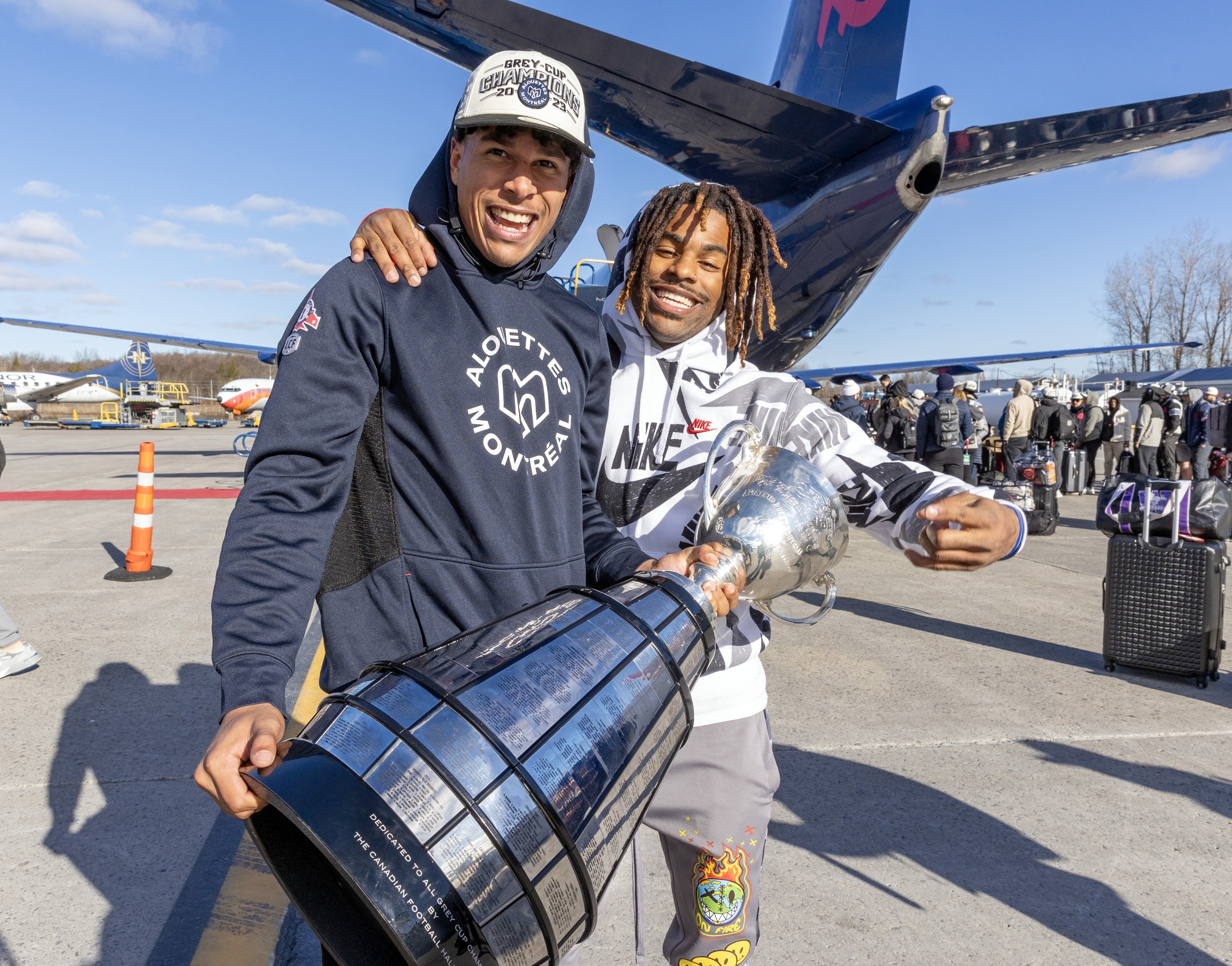 Alouettes receiver Tyson Philpot, left, who was named the top Canadian in the Grey Cup, and kick returner James Letcher Jr. arrive with the CFL trophy at Mirabel airport on Nov. 20, 2023.