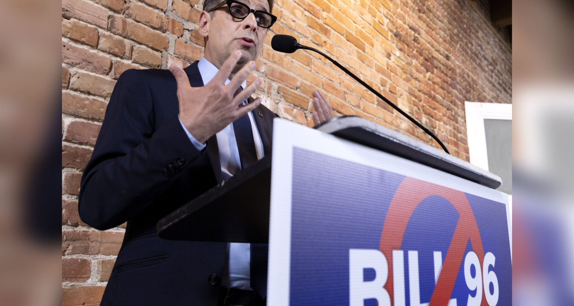 Eric Duhaime speaks at a podium with a sign on it saying no to Bill 96.