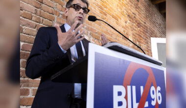 Eric Duhaime speaks at a podium with a sign on it saying no to Bill 96.