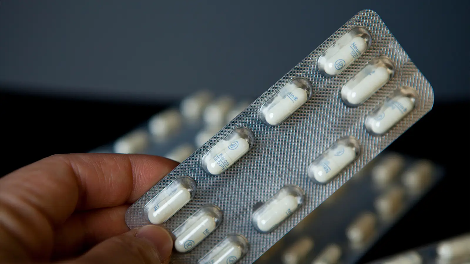A photo of a person holding a blisterpack of Neurontin capsules.