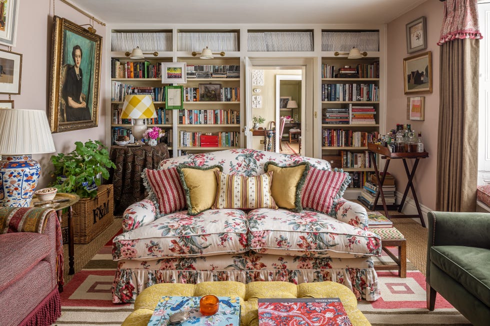 Cozy living room with floral couch and bookshelves.