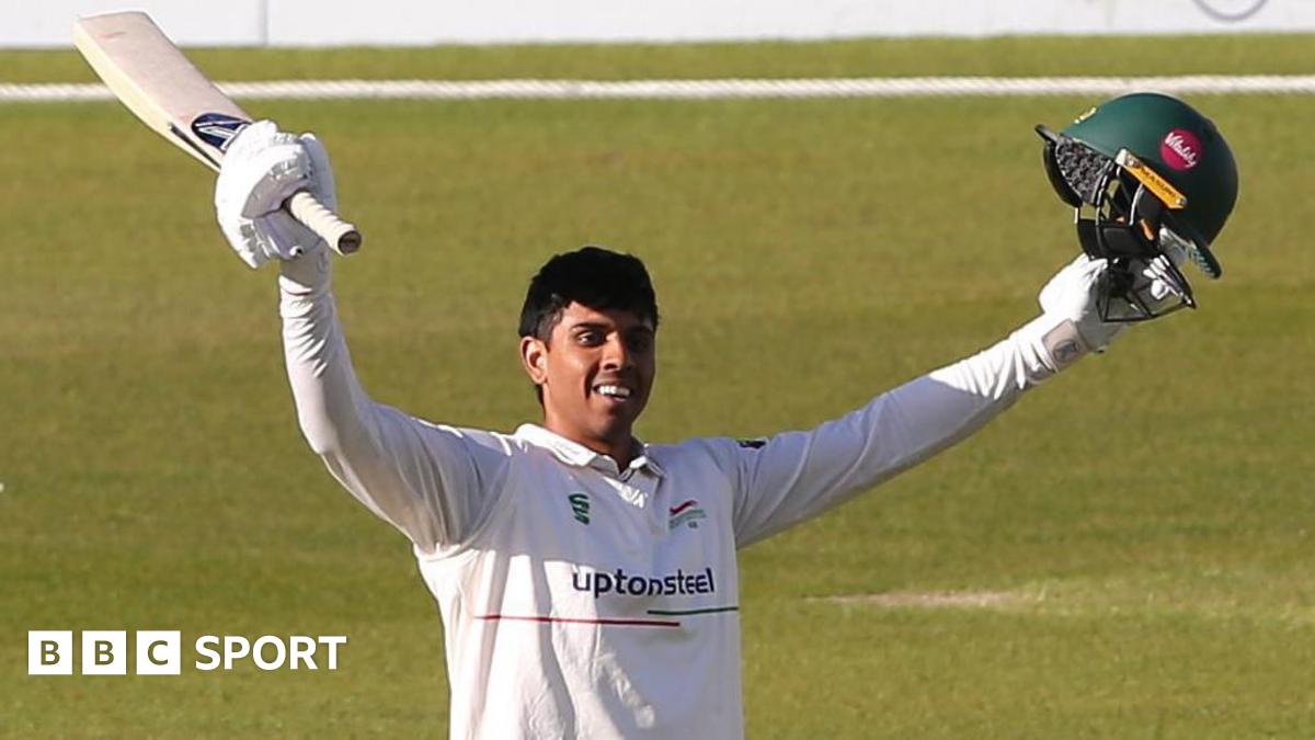 Rishi Patel raises his arms after scoring a century for Leicestershire