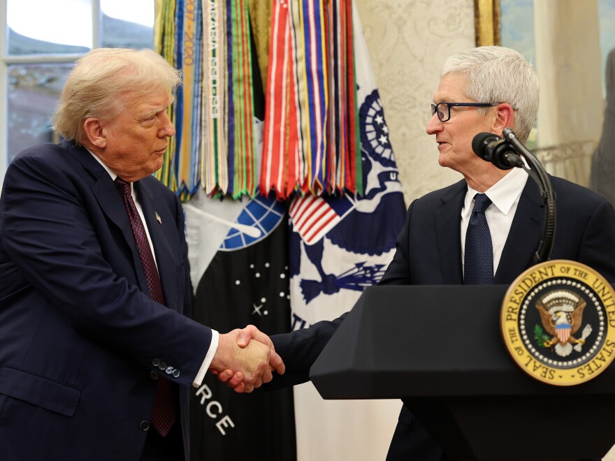 Apple CEO Tim Cook shakes hands with President Trump during an event in the White House's Oval Office on Aug. 6, 2025.