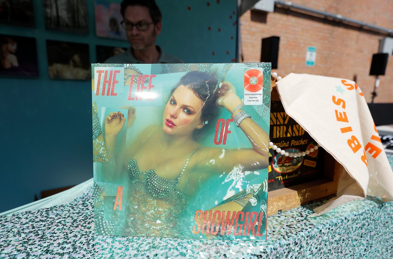 An album showing a woman in a bikini top is shown propped up on a table. The album bears the words 'The Life of a Showgirl.'