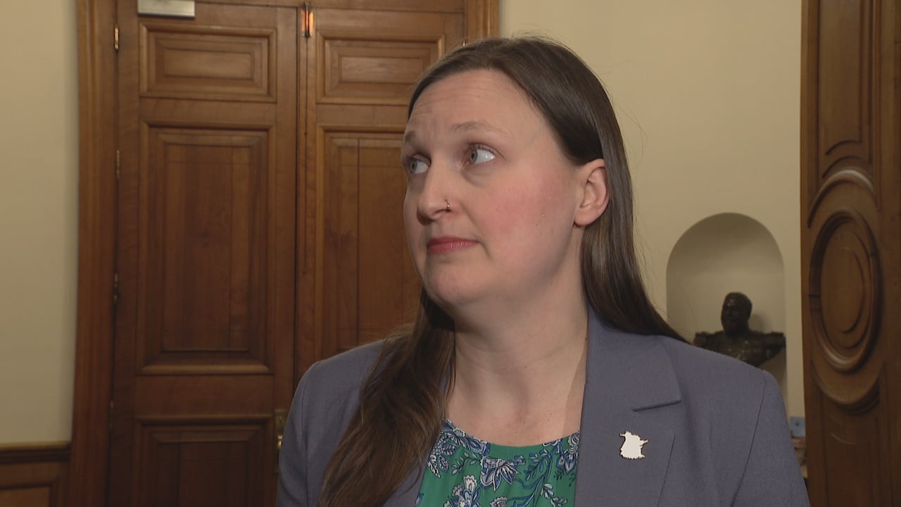 A woman looks to the left in a legislative building.
