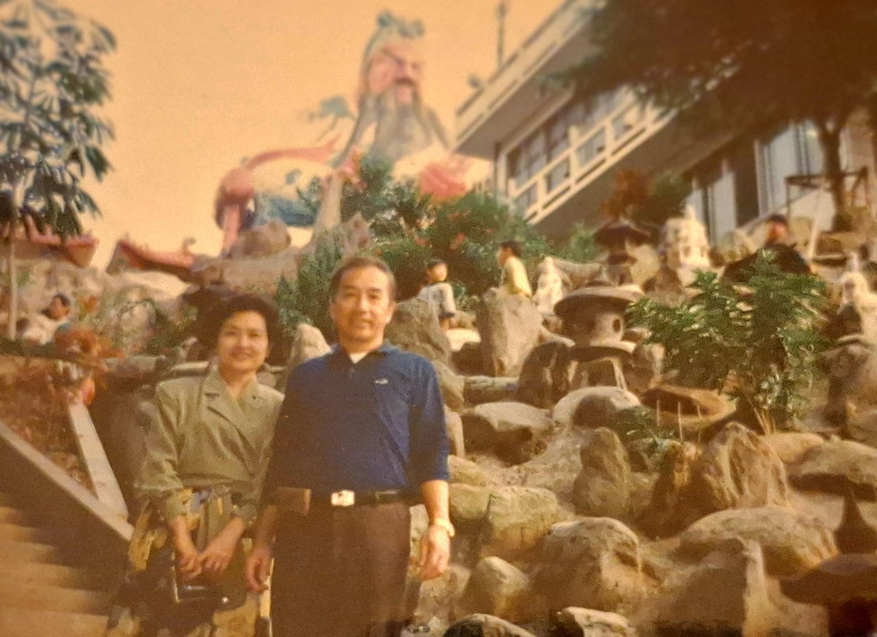 Two people stand on a staircase.