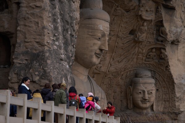Tourists take a tour as they visit the Yungang Grottoes in Datong, China, Friday, March 13, 2026. (AP Photo/Ng Han Guan)