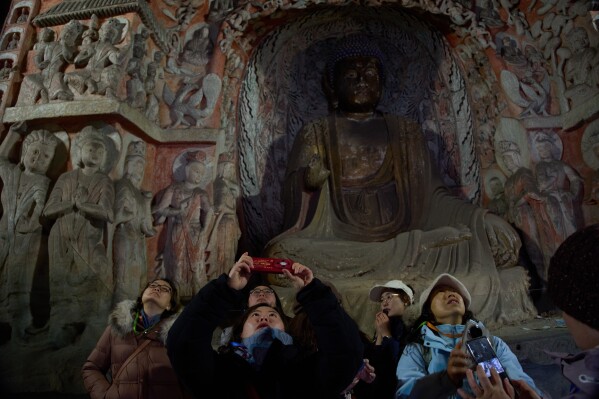 Tourists visit the Yungang Grottoes in Datong, China, Friday, March 13, 2026. (AP Photo/Ng Han Guan)